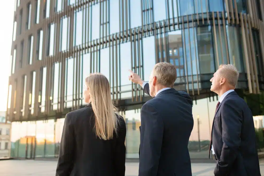 "A business meeting in progress with data charts on a digital screen